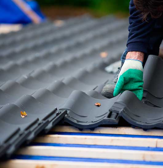 Man Laying Tiles on Roof
