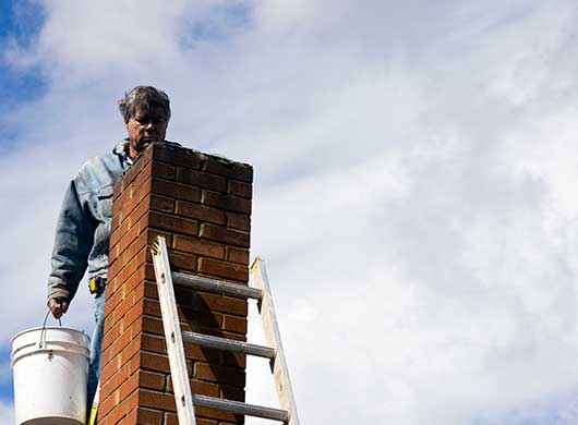 Man Repairing Brick Damaged Chimney
