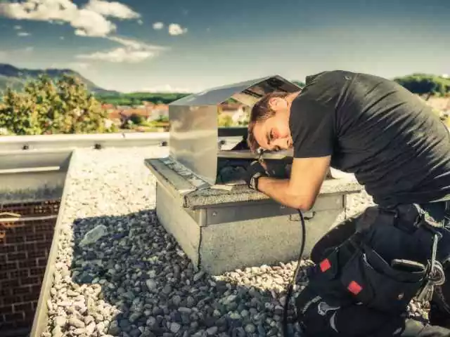 Chimney Sweep cleaning Fireplace on Building Roof